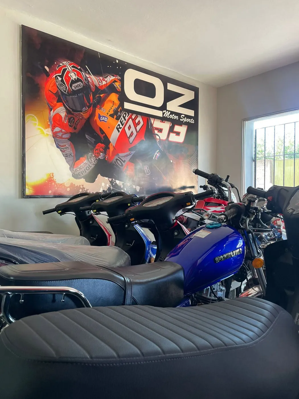 Salón de ventas de TodoMoto con motos exhibidas debajo de un cuadro de MotoGP