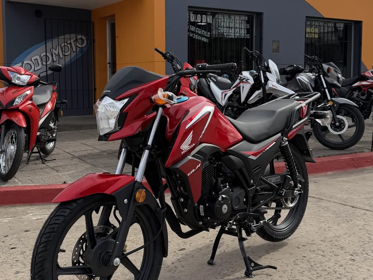 Honda GLH 150 0 km roja, vista lateral derecha en el salón de TodoMoto