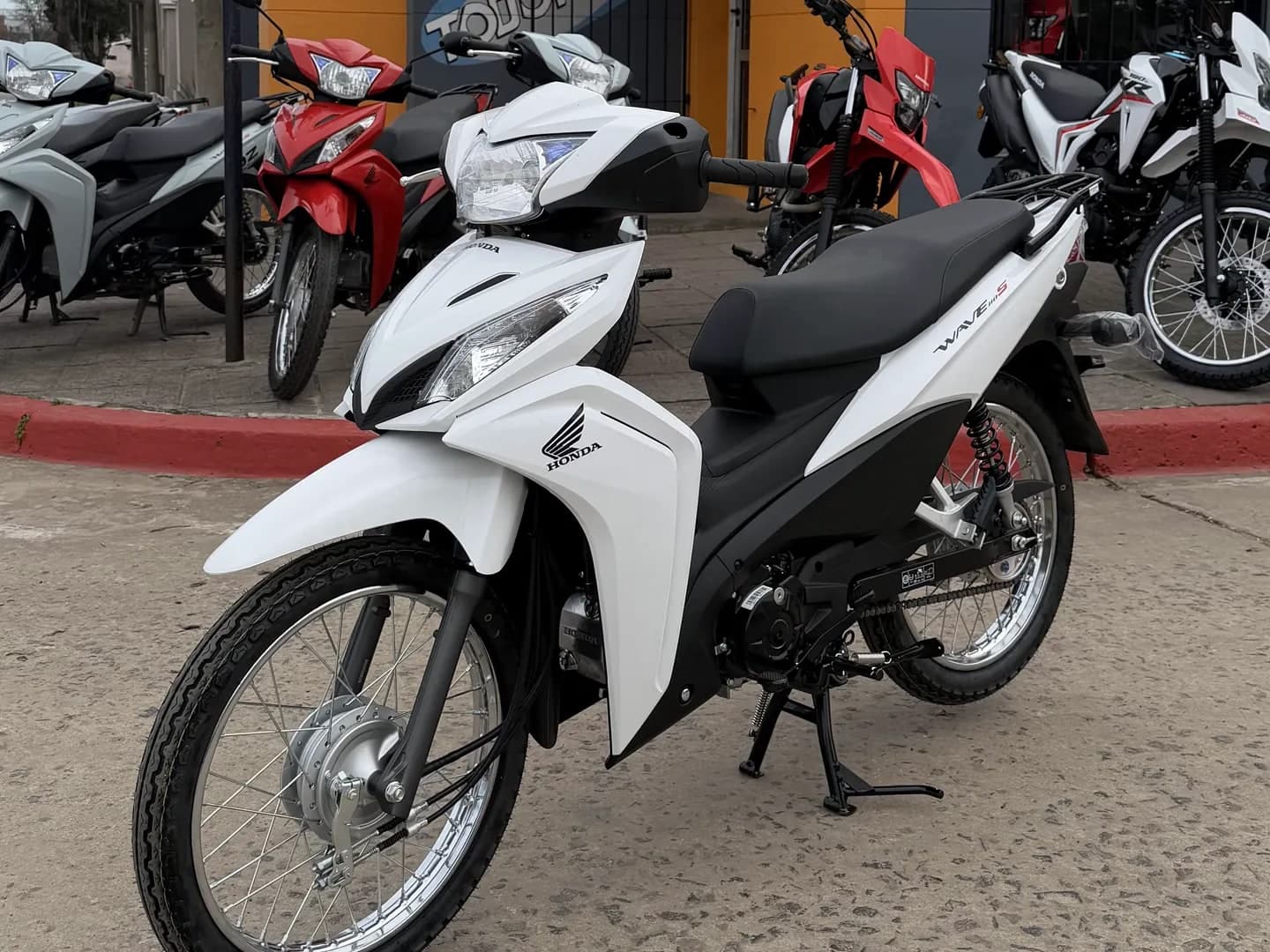 Honda Wave 110 0 km blanca, vista lateral derecha en el salón de TodoMoto