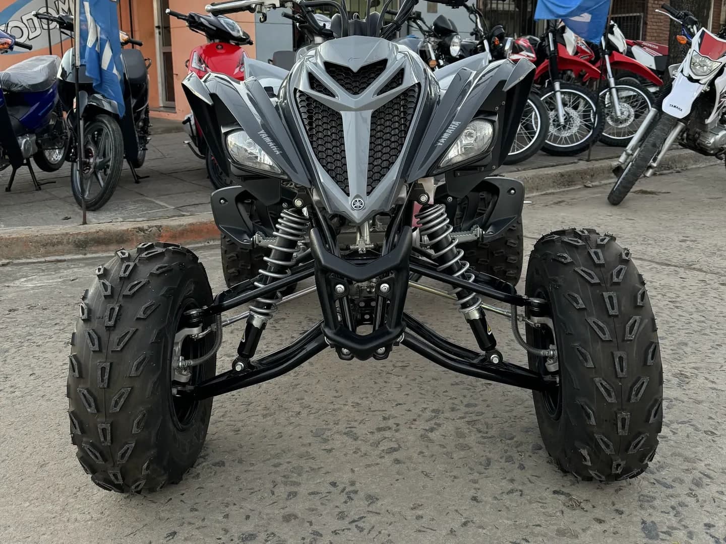 Cuatriciclo Yamaha Raptor 700 0 km gris y negro, vista tres cuartos delantera en el salón de TodoMoto