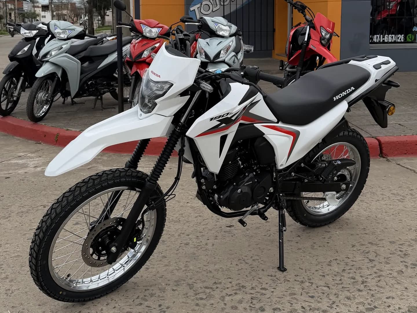 Honda XR 190L 0 km blanca y roja, vista lateral derecha en el salón de TodoMoto